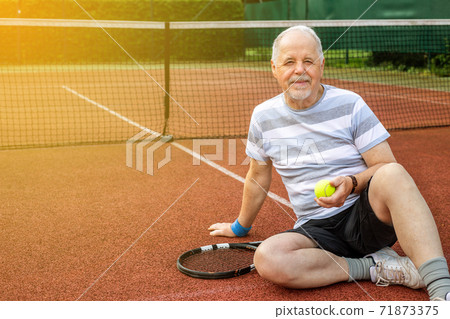 An active pensioner man playing tennis outside, enjoying lovely summer day, senior doing sport An active pensioner man playing tennis outside, enjoying lovely summer day, senior doing sport 71873375