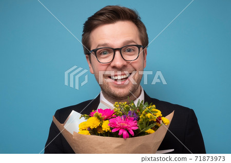 Smiling man holding a bouquet of flowers making a proposal. Smiling man holding a bouquet of flowers making a proposal. 71873973