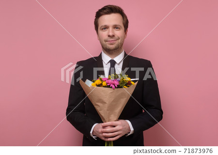 Smiling man holding a bouquet of flowers making a proposal. Smiling man holding a bouquet of flowers making a proposal. 71873976