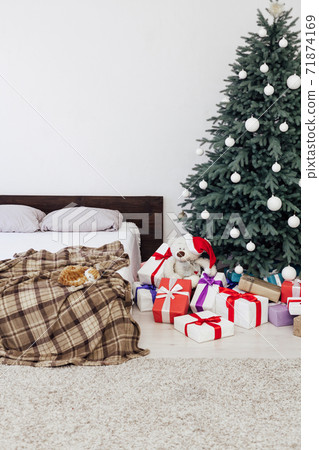 New year bedroom decor with Christmas tree bed with gifts and garlands interior New year bedroom decor with Christmas tree bed with gifts and garlands interior 71874169