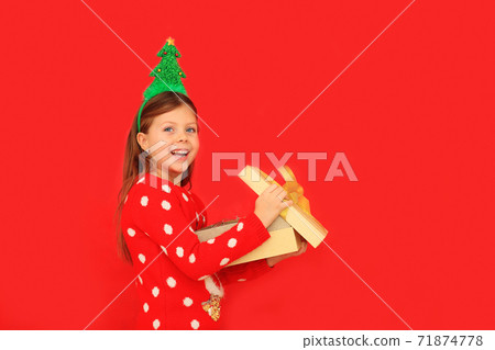 A child holding a gift for the new year A child holding a gift for the new year 71874778