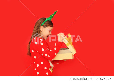 A child holding a gift for the new year A child holding a gift for the new year 71875497