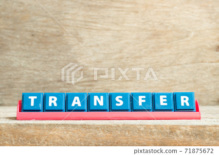 Tile letter on red rack in word transfer on wood background Tile letter on red rack in word transfer on wood background 71875672