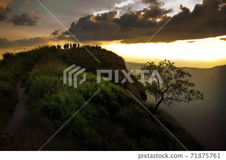 tourist on mountain top against beautiful sunset sky 71875761