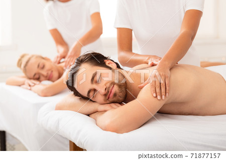 Husband Relaxing During Couples Massage With Wife At Spa Salon Husband Relaxing During Couples Massage With Wife At Spa Salon 71877157