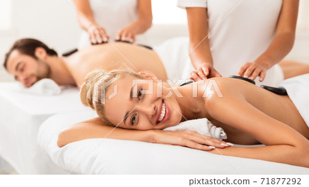 Happy Woman Getting Stone Massage On Couples Spa Procedure Indoors Happy Woman Getting Stone Massage On Couples Spa Procedure Indoors 71877292