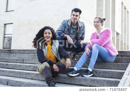 cute group of teenages at the building of university with books huggings, diversity nations real students lifestyle 71878897