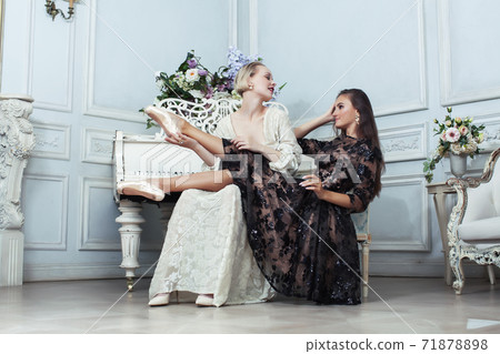 young pretty brunette ballet dancer at piano with blond woman in luxury royal interior, lifestyle rich people concept 71878898