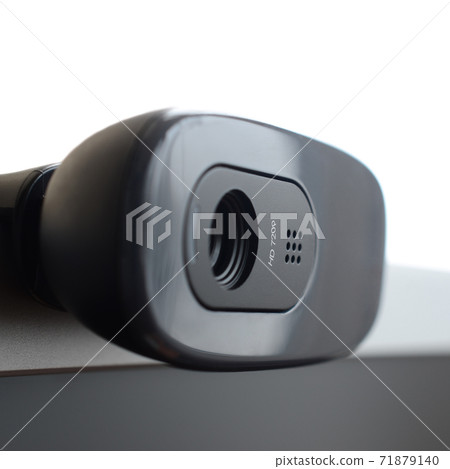 A modern web camera is installed on the body of a flat screen monitor. Device for video communication and recording of high quality video 71879140