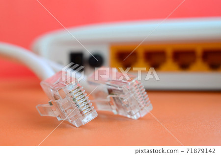 Internet router and Internet cable plugs lie on a bright orange background. Items required for Internet connection 71879142