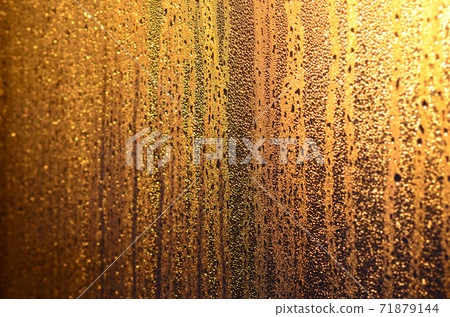 The texture of misted glass with a lot of drops and drips of condensation against the sunlight at dawn. Background image The texture of misted glass with a lot of drops and drips of condensation against the sunlight at dawn. Background image 71879144