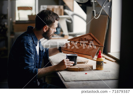 Woodworker applying glue to coards 71879387