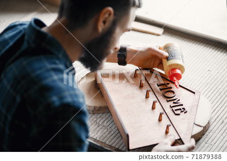 Woodworker applying glue to coards 71879388