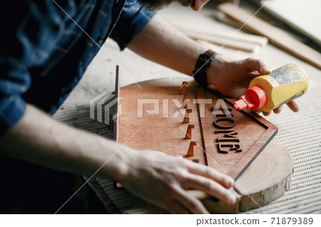 Woodworker applying glue to coards 71879389