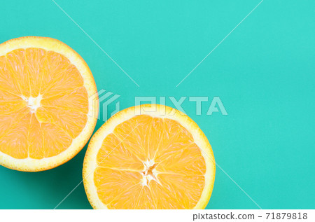 Top view of a several orange fruit slices on bright background in turquoise green color. A saturated citrus texture image 71879818