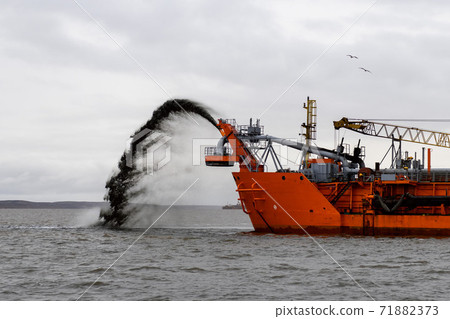 Vessel engaged in dredging. Dredger working at sea. Ship excavating material from a water environment. Vessel engaged in dredging. Dredger working at sea. Ship excavating material from a water environment. 71882373