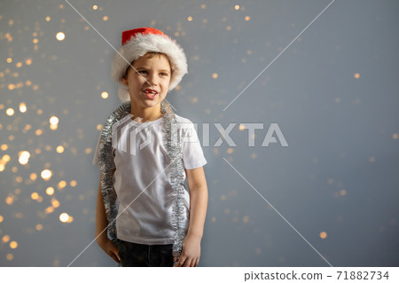 Boy in white T-shirt and Christmas hat. Boy in white T-shirt and Christmas hat. 71882734