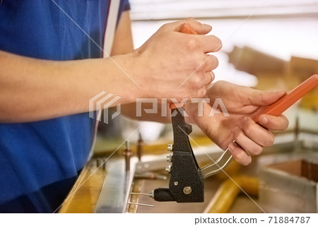 Pop rivet gun in action. 71884787