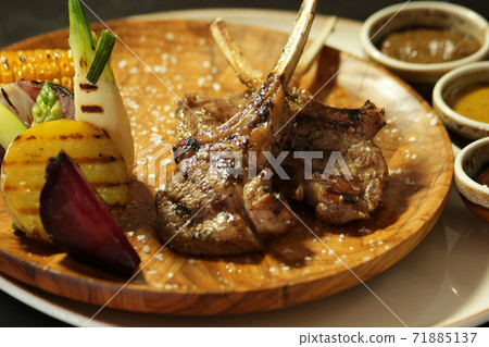 Lamb ribs elegantly served with vegetables. Lamb ribs elegantly served with vegetables. 71885137