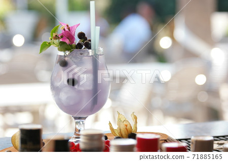 Summer cold drink with blueberry, ice and pink flower. Summer cold drink with blueberry, ice and pink flower. 71885165