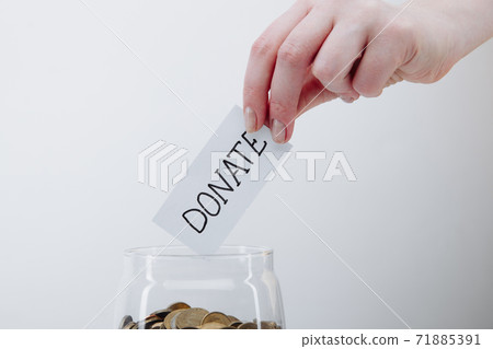 Female hands and glass bank with coins close-up. Charity and donation concept 71885391