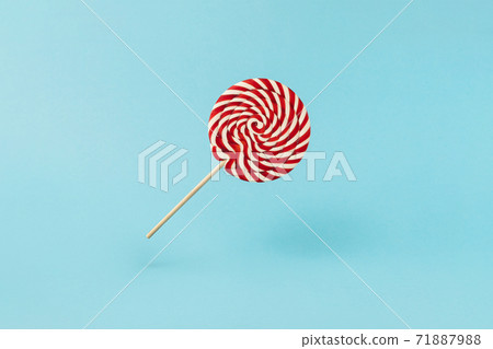 Colorful lolipop on blue background, wooden stick, red and white spiral, childhood sweets, Christmas concept Colorful lolipop on blue background, wooden stick, red and white spiral, childhood sweets, Christmas concept 71887988