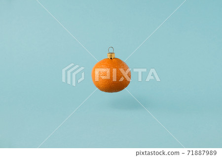 Christmas toy made from orange tangerine fruit. Minimal New Years concept. Levitation. Christmas toy made from orange tangerine fruit. Minimal New Years concept. Levitation. 71887989