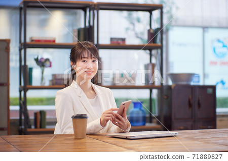一個女人在一個確定的辦公室中使用智能手機 一個女人在一個確定的辦公室中使用智能手機 71889827