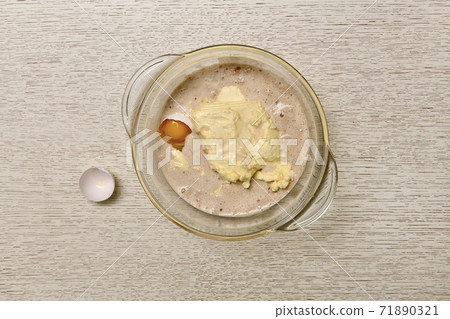 Bowl with kneaded ingredients, yeast, milk, eggs, butter for dough. Nearby shell.  71890321