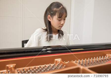 Girl during a piano lesson 71890793