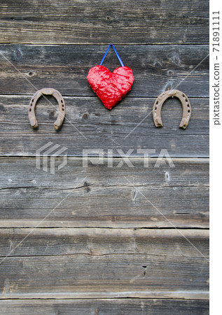 two rusty horseshoe and heart symbol on wooden wall 71891111