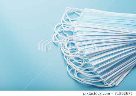 Stack of protective medical masks on a blue background, isolate. Stack of protective medical masks on a blue background, isolate. 71892675