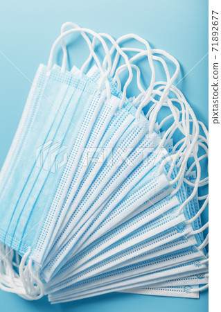 Medical protective masks on a blue background are stacked. Medical protective masks on a blue background are stacked. 71892677