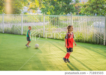 young boys playing football soccer game. Running players in uniforms young boys playing football soccer game. Running players in uniforms 71893503