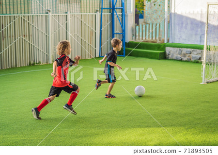 young boys playing football soccer game. Running players in uniforms 71893505