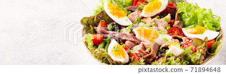 salad Nicoise with tuna, eggs, green beans, tomatoes,  olives, lettuce and anchovies 71894648