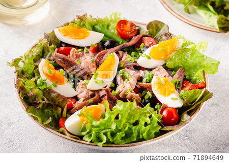 salad Nicoise with tuna, eggs, green beans, tomatoes,  olives, lettuce and anchovies 71894649
