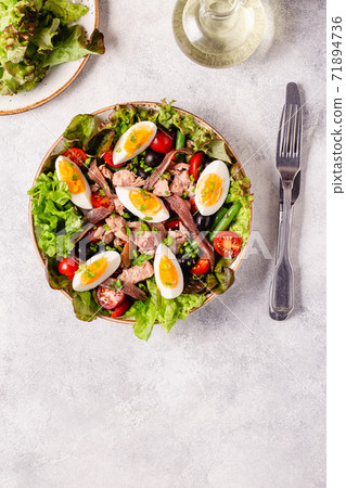 salad Nicoise with tuna, eggs, green beans, tomatoes,  olives, lettuce and anchovies 71894736