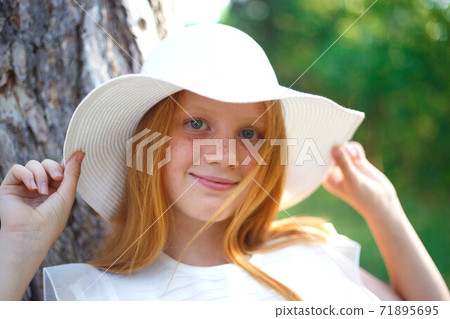 red-haired girl with freckles in white hat red-haired girl with freckles in white hat 71895695