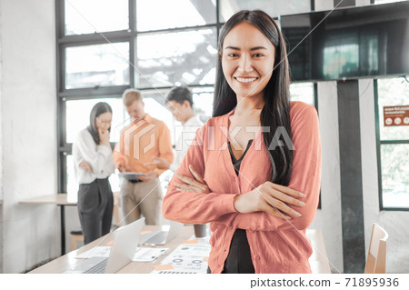 Young businesswoman standing with document near the office window, business concept Young businesswoman standing with document near the office window, business concept 71895936