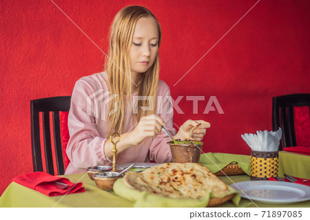 Caucasian Woman Eating Indian Food in Cafe. Traditional Indian dish. Indian food. Close-up Caucasian Woman Eating Indian Food in Cafe. Traditional Indian dish. Indian food. Close-up 71897085