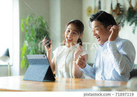 高興地看到這款平板電腦的男人和女人 高興地看到這款平板電腦的男人和女人 71897119