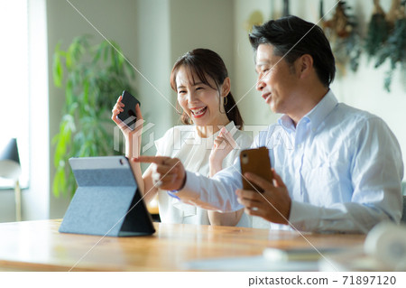高興地看到這款平板電腦的男人和女人 高興地看到這款平板電腦的男人和女人 71897120