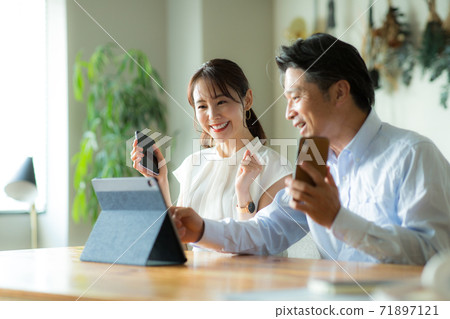 高興地看到這款平板電腦的男人和女人 高興地看到這款平板電腦的男人和女人 71897121