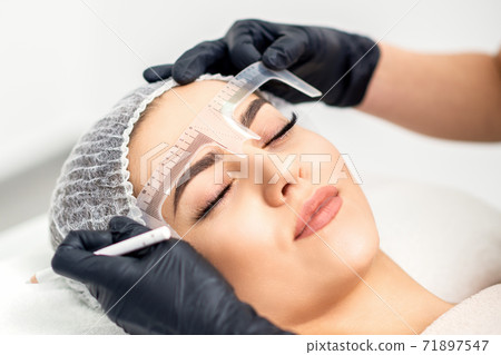 Beautician measuring brows with ruler Beautician measuring brows with ruler 71897547