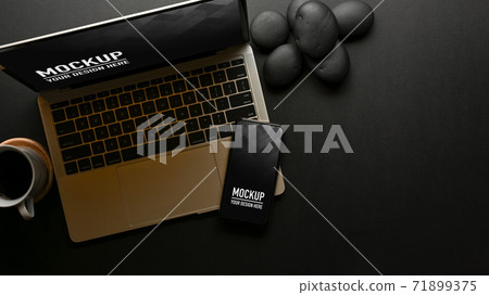 Top view of workspace with laptop, smartphone on black table Top view of workspace with laptop, smartphone on black table 71899375