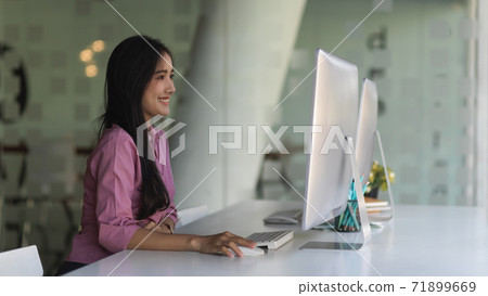 Female office worker working with computer and office supplies in office room 71899669