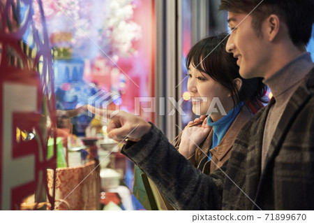 loving young asian couple looking at shop window and talking happy and smiling 71899670