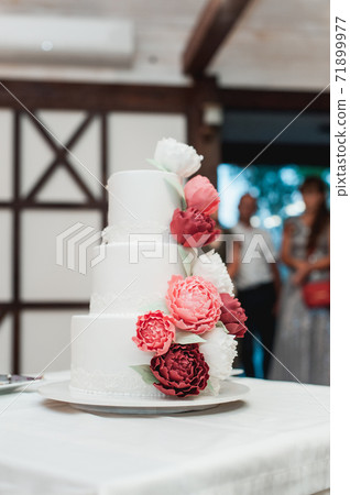 Beautiful wedding cake decorated with red roses Beautiful wedding cake decorated with red roses 71899977