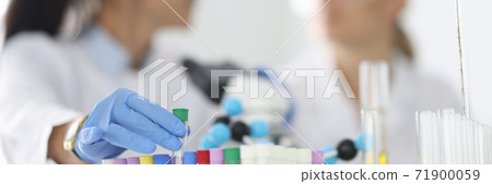 Women scientists hold glass test tubes in gloves in chemical laboratory closeup 71900059